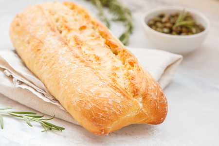 Fresh ciabatta with herbs on a light backgroundの写真素材