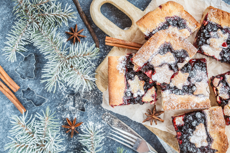 Sweet Christmas berry pie in Christmas decorations, dark background. Christmas food concept.の写真素材