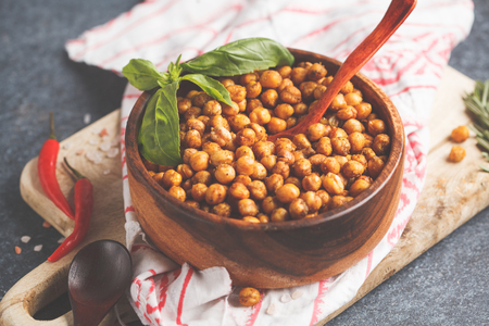 Healthy snack - baked spicy chickpeas in wooden bowl. Healthy vegan food concept.の写真素材