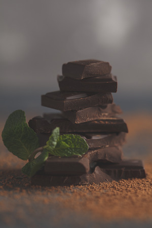 Stack of dark chocolate with mint. Dark background, copy space. Macroの写真素材