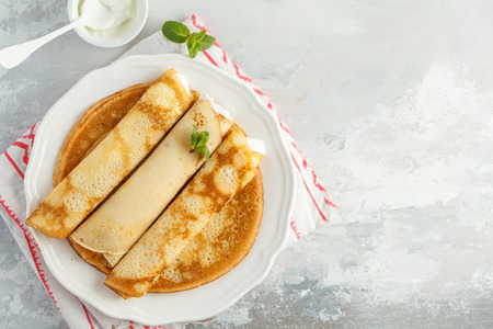 Thin hot pancakes with cottage cheese and strawberries. Healthy traditional breakfast concept.の写真素材