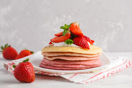 Stack of pink ombre  pancakes with marshmallow. Breakfast background, copy space.