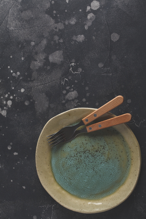 Beautiful vintage yellow-blue empty plate on a dark background. Copy space, top view.の写真素材