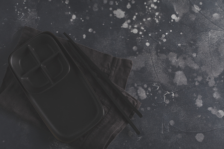 Black dish and chopsticks for Japanese food on a dark background. Copy space, top view.の写真素材
