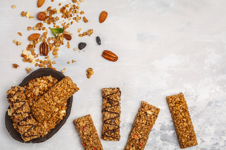 Granola bars and ingredients. Healthy sweet dessert snack. Vegan granola bar with nuts, chocolate  and berries on a white background. Top view, copy space.の写真素材