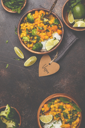 Vegan Sweet Potato Chickpea curry in wooden bowl on a dark background. Healthy vegetarian food concept.の写真素材