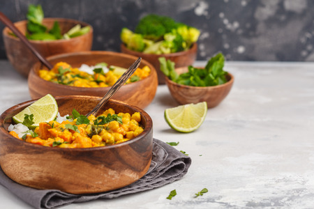 Vegan Sweet Potato Chickpea curry in wooden bowl on a light background. Healthy vegetarian food...