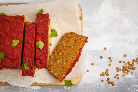 Vegetarian lentil casserole with vegetables and tomato sauce on a wooden board. Healthy vegan food concept.の写真素材
