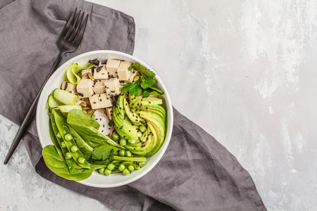 Green buddha bowl with tofu, rice, avocado and vegetables. Go vegan concept.の写真素材