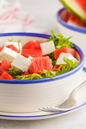 Watermelon and feta cheese salad in a white plate on a white background. Healthy summer foodの写真素材