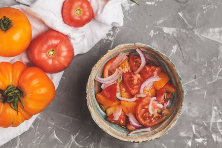 Tomato salad with onions. Healthy vegetarian food. Top view, gray background.の写真素材