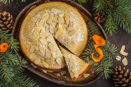 Traditional Christmas (Norwegian) almond cake in Christmas decorations, dark background. Christmas dessert concept.の写真素材