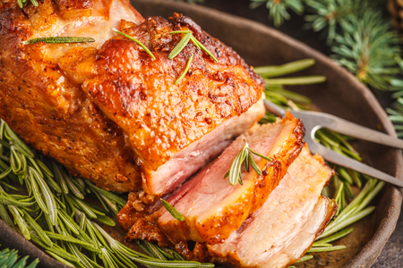 Baked Christmas pork (ham) with rosemary. Christmas table, white background.の写真素材