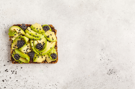Avocado toast on a healthy sesame bread with sesame seeds on white background, copy space. Healthy vegan food concept.の写真素材