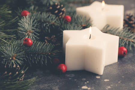 A star candle burns on a christmas table.