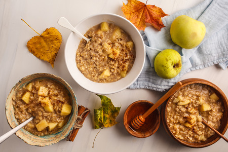 Healthy breakfast flat lay. Apple oatmeal with cinnamon and honey. White background, top view.の写真素材