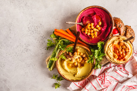 Different hummus bowls. Chickpea hummus, avocado hummus and beet hummus. Plant based diet food.の写真素材