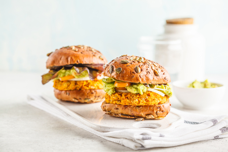 Vegan sweet potato (or pumpkin) burgers on white background. Vegetable burgers, avocado, vegetables and buns. Clean eating, plant based food concept.の写真素材