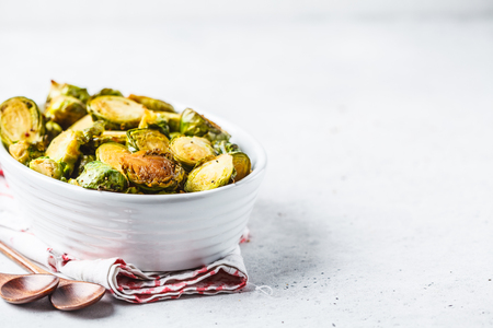 Baked brussels sprouts on a white plate. Plant based diet concept.の写真素材