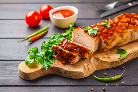Baked meat loaf with greens and barbecue sauce on a wooden board. American cuisine concept.の写真素材