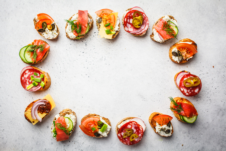 Assorted spanish tapas with fish, sausage, cheese and vegetables. White background, frame food, copy space.の写真素材