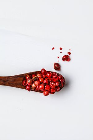 Red peas paprika on wooden spoon, white background.の写真素材