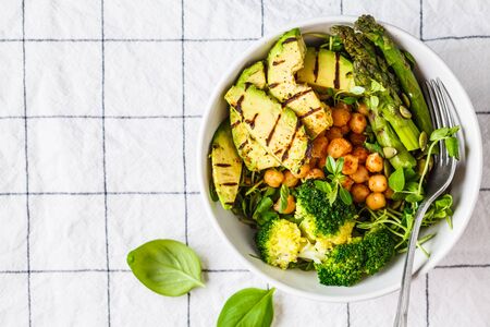 Buddha bowl with grilled avocado, asparagus, chickpeas, pea sprouts and broccoli. Vegan food concept.の写真素材