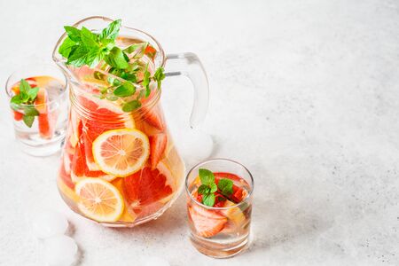 Grapefruit lemonade with lemon and mint in a glass jug.の写真素材