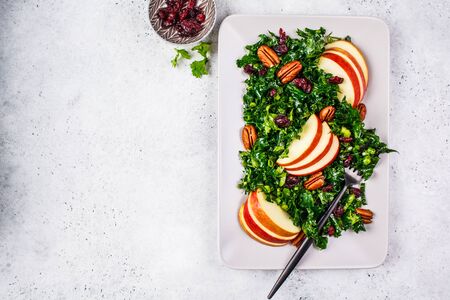 Healthy vegan salad with apple, cranberry, kale and pecan in rectangular plate, copy space.の写真素材
