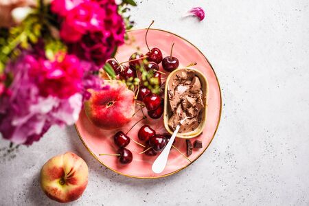 Beautiful pink food background. Flowers and berries on a pink plate. Summer food background.の写真素材