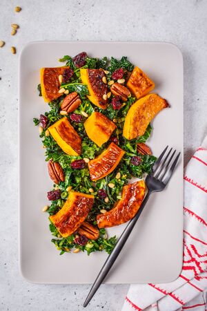 Pumpkin salad with nuts, cranberries and kale in rectangular plate.の写真素材