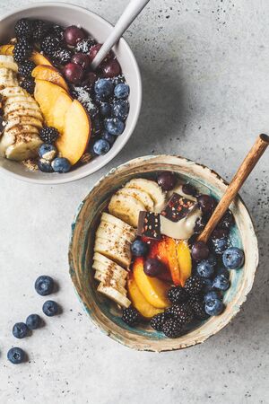 Overnigth oatmeal with fruits, berries and super foods in bowls. Healthy vegan food concept.の写真素材