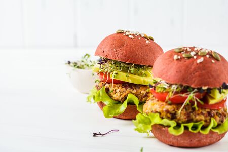 Pink vegan burgers with beans cutlet, avocado and seedlings on a white background.の写真素材