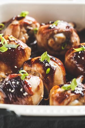 Oven-baked teriyaki chicken with green onion and sesame seeds, close up.の写真素材