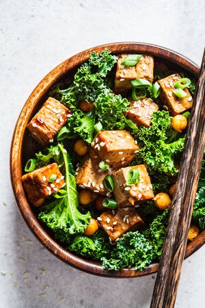 Teriyaki tofu salad with kale and chickpeas in wooden bowl.の写真素材