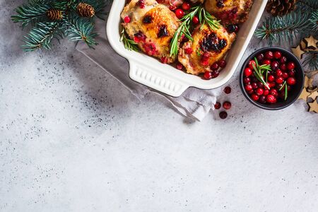 Christmas food. Chicken meat baked with cranberries and rosemary in the oven dish, top view.の写真素材