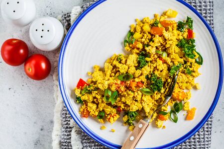 Tofu scramble with vegetables in white plate. Vegan Alternative food concept.の写真素材