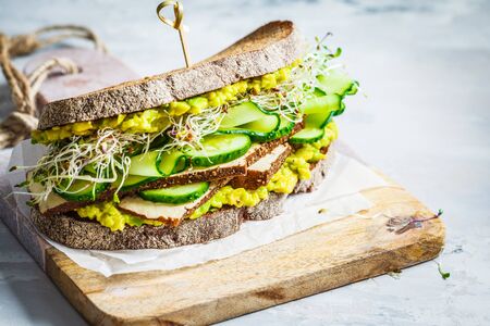 Big green sandwich with tofu, vegetables, sprouts and guacamole. Healthy vegan food concept.の写真素材