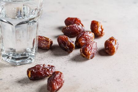 Dates and a glass of water, copy space. Iftar food concept.