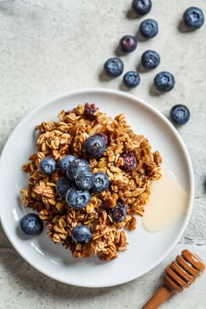 Baked oatmeal with blueberries and honey in on a white plate, copy space. Oatmeal fruit crumble pie.の写真素材