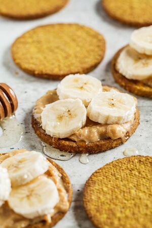 Peanut butter, banana and honey crackers. Vegan food concept.の写真素材