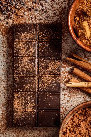 Ingredients for making chocolate background. Cocoa, cocoa butter, sugar, cinnamon and coconut oil on a dark background. Chocolate concept.の写真素材