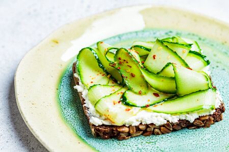 Cucumber and cream cheese toast on a plate. Healthy vegetarian diet concept.