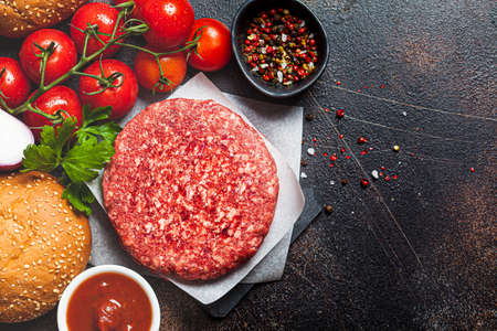 Raw ingredients for burgers, dark background, copy space. Cooking background.