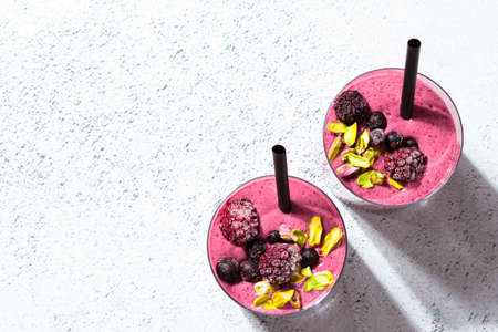Berry smoothie with nuts in glasses, light background, minimalism. Healthy detox drink concept.の写真素材