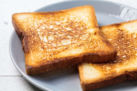 Toast with butter and apricot jam on a gray plate. Breakfast food concept.