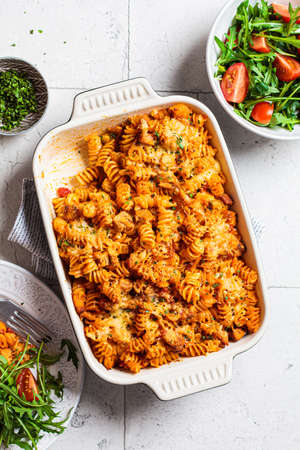 Baked pasta with chicken and cheese in the oven dish, gray background. Italian cuisine concept.の写真素材