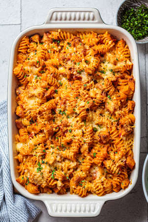 Baked pasta with chicken and cheese in the oven dish, gray background. Italian cuisine concept.の写真素材