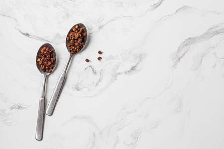Sichuan peppercorn in a spoon on a white marble background.の写真素材