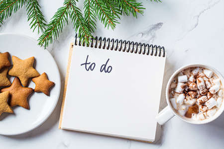 Christmas background. To-do list and festive cocoa with marshmallows on white marble, top view. New Years resolutions concept.の写真素材